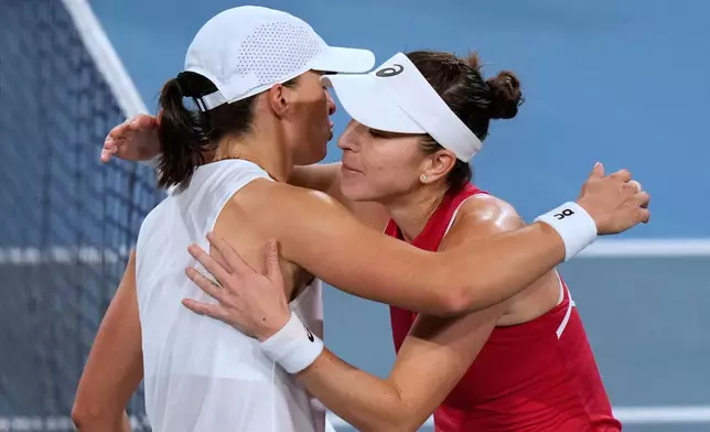 Belinda Bencic of Switzerland, right, and Iga Swiatek of Poland meet at the net after Bencic won their final match at the United Cup tennis tournament in Sydney, Sunday, Jan. 11, 2026. (AP Photo/Rick Rycroft)