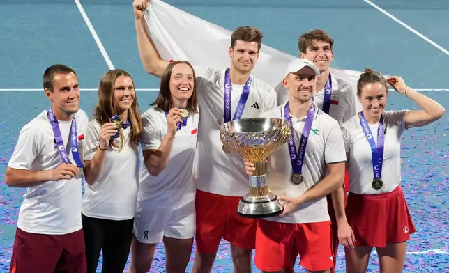 Teammembers from Poland celebrate with their trophy after defeating Switzerland in the final at the United Cup tennis tournament in Sydney, Monday, Jan. 12, 2026. (AP Photo/Rick Rycroft)