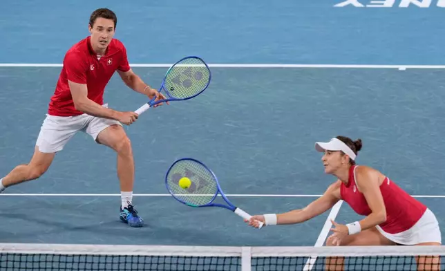 Belinda Bencic, right, and Jakub Paul of Switzerland compete against Katarzyna Kawa and Jan Zielinski of Poland in the doubles final match at the United Cup tennis tournament in Sydney, Sunday, Jan. 11, 2026. (AP Photo/Rick Rycroft)