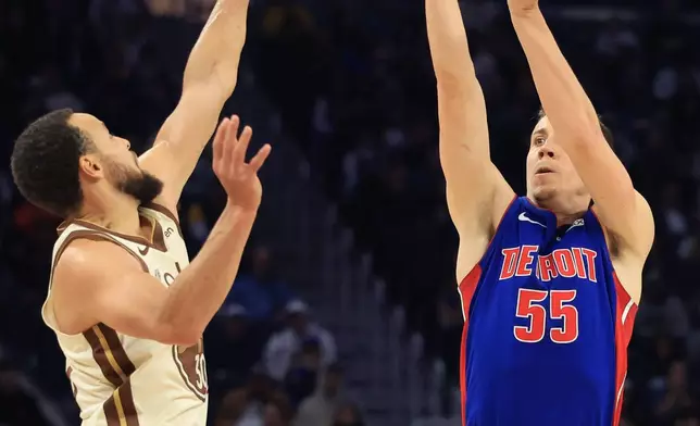 Detroit Pistons forward Duncan Robinson (55) shoots against Golden State Warriors guard Stephen Curry, left, during the first half of an NBA basketball game in San Francisco, Friday, Jan. 30, 2026. (AP Photo/Jed Jacobsohn)