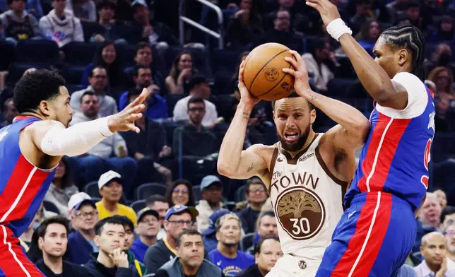 Golden State Warriors guard Stephen Curry (30) is double teamed by the Detroit Pistons in the first half of an NBA game in San Francisco, Friday, Jan. 30, 2026. (Santiago Mejia/San Francisco Chronicle via AP)