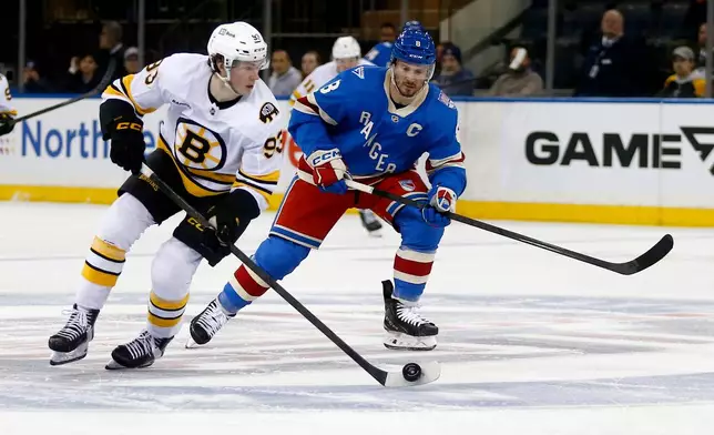 Boston Bruins center Fraser Minten, left, skates past New York Rangers center J.T. Miller, right, during the second period of an NHL hockey game Monday, Jan. 26, 2026, in New York. (AP Photo/John Munson)