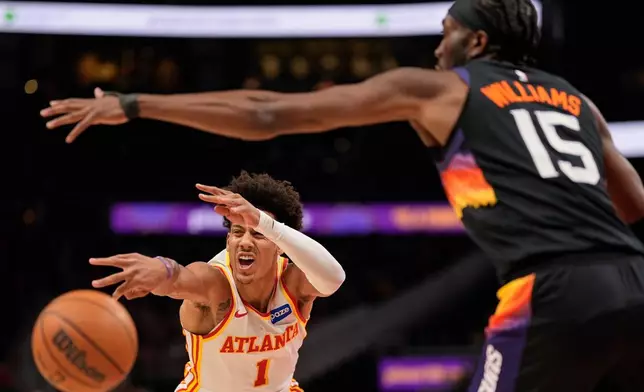 Atlanta Hawks forward Jalen Johnson (1) passes against Phoenix Suns center Mark Williams (15) during the first half of an NBA basketball game, Friday, Jan. 23, 2026, in Atlanta. (AP Photo/Mike Stewart)