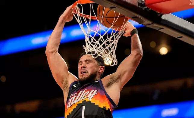 Phoenix Suns guard Devin Booker (1) dunks against the Atlanta Hawks during the second half of an NBA basketball game, Friday, Jan. 23, 2026, in Atlanta. (AP Photo/Mike Stewart)