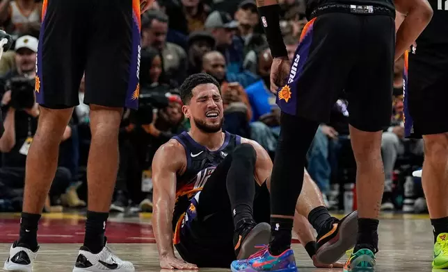 Phoenix Suns guard Devin Booker (1) winces in pain during the second half of an NBA basketball game against the Atlanta Hawks, Friday, Jan. 23, 2026, in Atlanta. (AP Photo/Mike Stewart)