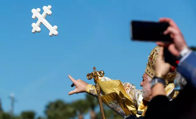 His Eminence Archbishop Elpidophoros of the Greek Orthodox Archdiocese of America tosses the cross into the water during the annual cross dive in the Spring Bayou, part of the Epiphany celebration on Tuesday, Jan. 6, 2026, in Tarpon Springs, Fla. (Jefferee Woo /Tampa Bay Times via AP)