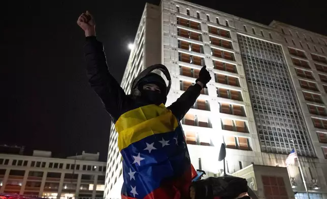 A Venezuelan immigrant critical of Venezuelan President Nicolas Maduro celebrates while wearing the country's flag outside the Metropolitan Detention Center, Saturday, Jan. 3, 2026, in New York. (AP Photo/Yuki Iwamura)