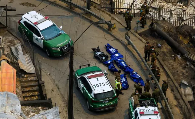 FILE - Police recover the bodies of people who died after wildfires swept through homes near Lirquen, Chile, Jan. 18, 2026. (AP Photo/Javier Torres, File)