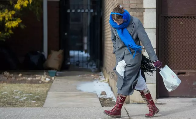 A person walks in the cold and wind Wednesday, Jan. 21, 2026, in Chicago. (AP Photo/Erin Hooley)