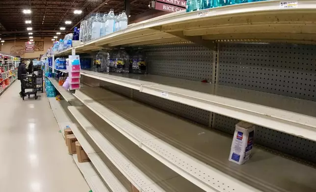 Shelves that once contained water are picked over at a Pittsburgh market ahead of a snowstorm Saturday, Jan. 24, 2026. (AP Photo/Gene J. Puskar)