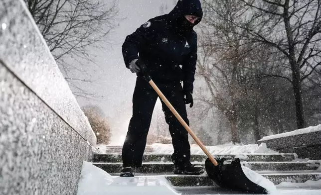 Workers with Architect of the Capitol shovel snow near the U.S. Capitol, Sunday, Jan. 25, 2026, in Washington. (AP Photo/Julia Demaree Nikhinson)