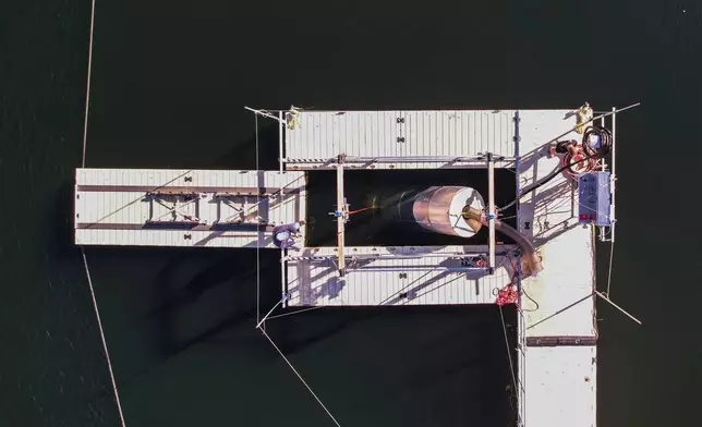 A prototype OceanWell reverse osmosis pod is lowered into Las Virgenes Reservoir in Westlake Village, Calif., Monday, Dec. 1, 2025, where the deep sea desalination technology is being tested. (AP Photo/Annika Hammerschlag)
