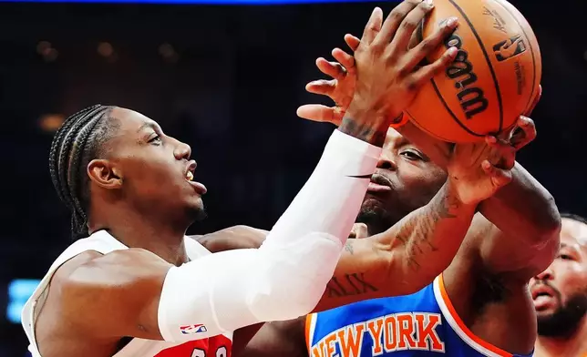 Toronto Raptors' RJ Barrett (left) is fouled by New York Knicks' Og Anunoby (8) during first half NBA basketball action in Toronto on Wednesday, Jan. 28, 2026. (Frank Gunn/The Canadian Press via AP)