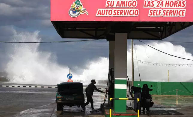 People refuel their car and motorcycle at a gas station near the Malecon in Havana, Cuba, Tuesday, Jan. 27, 2026. (AP Photo/Ramon Espinosa)