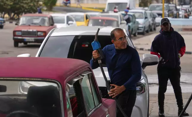 A driver refuels others wait in a long line behind to fill up at a gas station in Havana, Cuba, Tuesday, Jan. 27, 2026. (AP Photo/Ramon Espinosa)