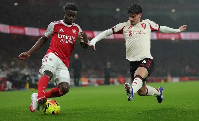 Liverpool's Milos Kerkez blocks Arsenal's Bukayo Saka during the English Premier League soccer match between Arsenal and Liverpool in London, Thursday, Jan. 8, 2026. (AP Photo/Ian Walton)