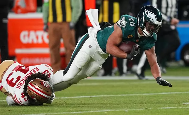Philadelphia Eagles running back Saquon Barkley is stopped by San Francisco 49ers' Eric Kendricks during the first half of an NFL wild-card playoff football game Sunday, Jan. 11, 2026, in Philadelphia. (AP Photo/Matt Rourke)