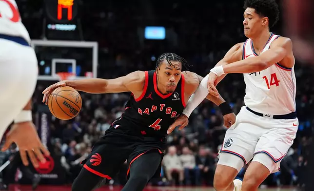 Toronto Raptors' Scottie Barnes (4) drives past Los Angeles Clippers' Yanic Konan Niederhauser (14) during second-half NBA basketball game action in Toronto, Friday, Jan. 16, 2026. (Frank Gunn/The Canadian Press via AP)