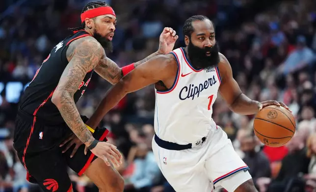 Los Angeles Clippers' James Harden (1) drives past Toronto Raptors' Brandon Ingram, left, during first-half NBA basketball game action in Toronto, Friday, Jan. 16, 2026. (Frank Gunn/The Canadian Press via AP)