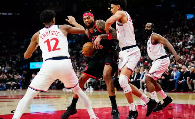 Toronto Raptors' Brandon Ingram, center, battles with Los Angeles Clippers' Cam Christie (12) and Kobe Sanders, second from right, during second-half NBA basketball game action in Toronto, Friday, Jan. 16, 2026. (Frank Gunn/The Canadian Press via AP)