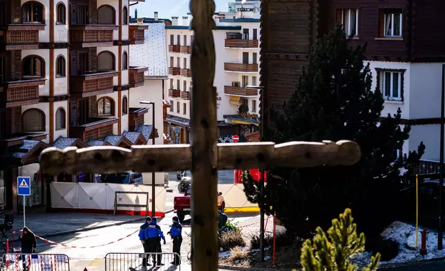 Police officers inspect the area where a fire broke out at the Le Constellation bar and lounge leaving people dead and injured, during New Year’s celebration, in Crans-Montana, Swiss Alps, Switzerland, Thursday, Jan. 1, 2026. (Jean-Christophe Bott/Keystone via AP)