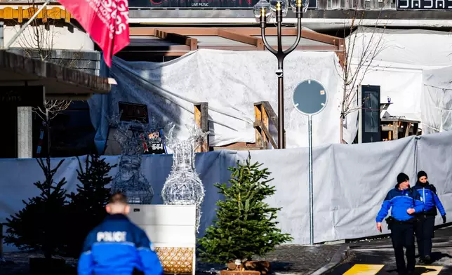 Police officers inspect the area where a fire broke out at the Le Constellation bar and lounge leaving people dead and injured, during New Year’s celebration, in Crans-Montana, Swiss Alps, Switzerland, Thursday, Jan. 1, 2026. (Jean-Christophe Bott/Keystone via AP)