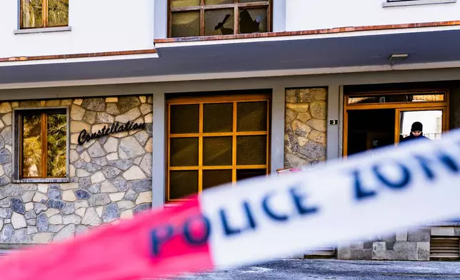 Police officers inspect the area where a fire broke out at the Le Constellation bar and lounge leaving people dead and injured, during New Year’s celebration, in Crans-Montana, Swiss Alps, Switzerland, Thursday, Jan. 1, 2026. (Jean-Christophe Bott/Keystone via AP)