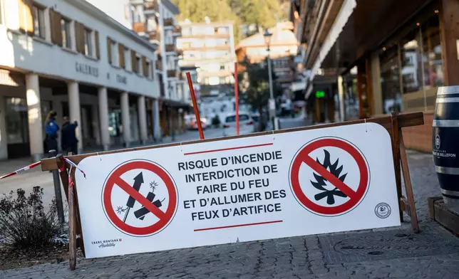A banner stating that fireworks are prohibited due to the risk of fire is pictured near the area where a fire broke out at the Le Constellation bar and lounge leaving people dead and injured, during New Year’s celebration, in Crans-Montana, Swiss Alps, Switzerland, Thursday, Jan. 1, 2026. (Alessandro della Valle/Keystone via AP)