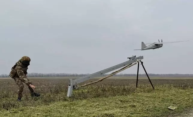 In this image made from video provided by Russian Defense Ministry Press Service on Sunday, Feb. 15, 2026, shows a Russian serviceman launches an Orlan-10 reconnaissance drone tfor an action in an undisclosed location in Ukraine. (Russian Defense Ministry Press Service via AP)
