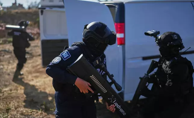 Officers of Michoacan state's Specialized Investigation Subsecretariat use an anti-drone signal jammer during a demonstration for the press in Morelia, Mexico, Wednesday, March 26, 2025. (AP Photo/Eduardo Verdugo)
