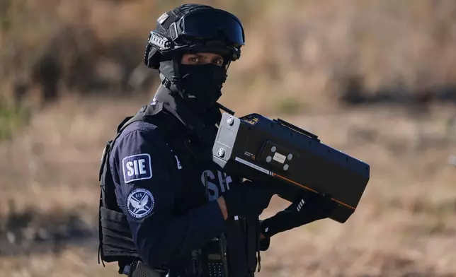 An officer of Michoacan state's Specialized Investigation Subsecretariat uses an anti-drone signal jammer during a demonstration for the press in Morelia, Mexico, Wednesday, March 26, 2025. (AP Photo/Eduardo Verdugo)