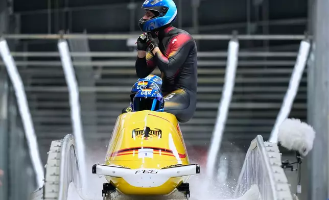 Germany's Johannes Lochner, front, Thorsten Margis, Jorn Wenzel and Georg Fleischauer arrive at the finish during a four man bobsled run at the 2026 Winter Olympics, in Cortina d'Ampezzo, Italy, Sunday, Feb. 22, 2026. (AP Photo/Aijaz Rahi)