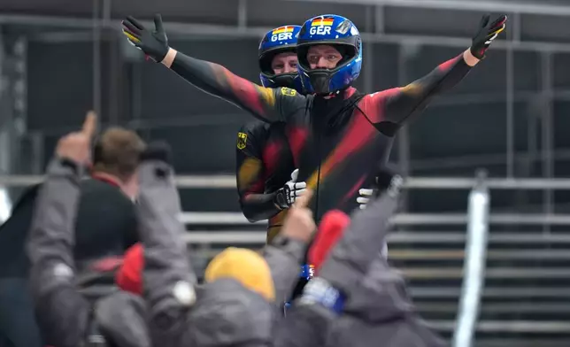 Germany's gold medalists Johannes Lochner, front, Thorsten Margis, Jorn Wenzel and Georg Fleischauer arrive at the finish during a four man bobsled run at the 2026 Winter Olympics, in Cortina d'Ampezzo, Italy, Sunday, Feb. 22, 2026. (AP Photo/Aijaz Rahi)