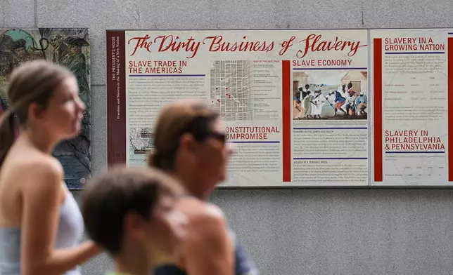 FILE - People walk past an informational panel at President's House Site Tuesday, Aug. 19, 2025, in Philadelphia. (AP Photo/Matt Rourke, File)