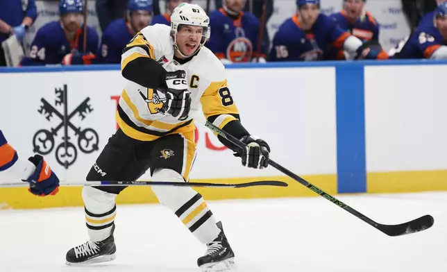 Pittsburgh Penguins center Sidney Crosby passes the puck during the first period of an NHL hockey game against the New York Islanders, Tuesday, Feb. 3, 2026, in Elmont, N.Y. (AP Photo/Heather Khalifa)