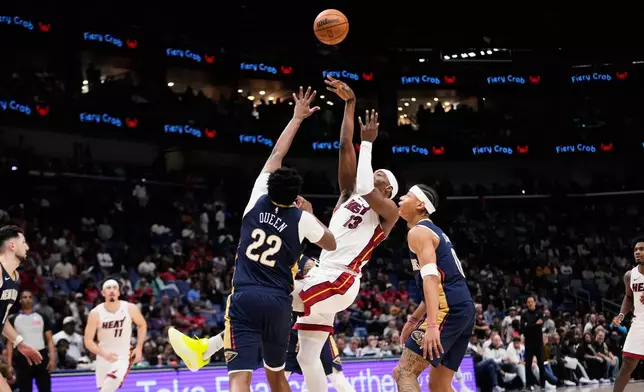 Miami Heat center Bam Adebayo (13) shoots against New Orleans Pelicans center Derik Queen (22) and guard Jeremiah Fears (0) in the second half of an NBA basketball game, Wednesday, Feb. 11, 2026, in New Orleans. (AP Photo/Gerald Herbert)