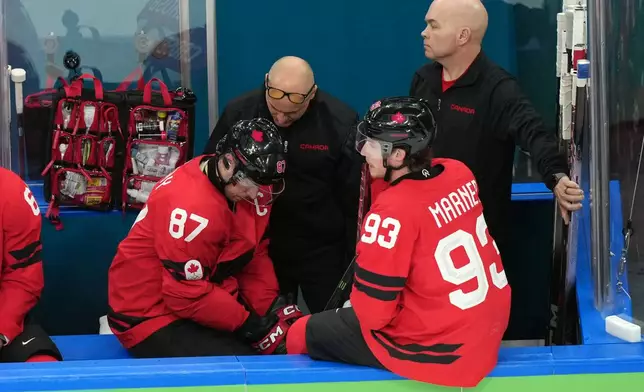 Canada's Sidney Crosby (87) is attended to after being injured during the second period of a men's ice hockey quarterfinal game between Canada and Czechia at the 2026 Winter Olympics, in Milan, Italy, Wednesday, Feb. 18, 2026. (AP Photo/Hassan Ammar)