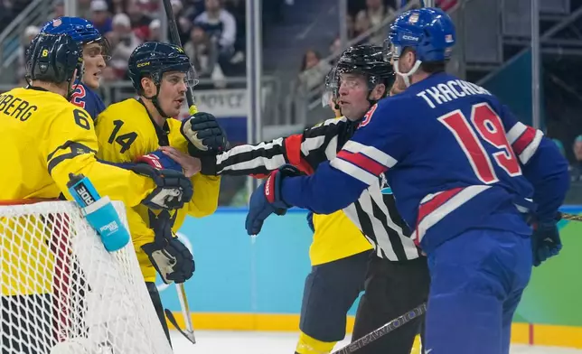 Sweden's Joel Eriksson Ek (14) and United States' Matthew Tkachuk (19) are kept apart during the second period of a men's ice hockey quarterfinal game at the 2026 Winter Olympics, in Milan, Italy, Wednesday, Feb. 18, 2026. (AP Photo/Hassan Ammar)