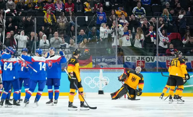 Germany players are dejected as Slovakia players celebrate their fifth goal during a men's ice hockey quarterfinal game between Slovakia and Germany at the 2026 Winter Olympics, in Milan, Italy, Wednesday, Feb. 18, 2026. (AP Photo/Petr David Josek)