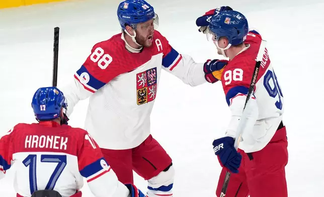 Czechia's David Pastrnak (88) celebrates with Martin Necas (98) and Filip Hronek (17) after Pastrnak scored a goal against Canada during the first period of a men's ice hockey quarterfinal game at the 2026 Winter Olympics, in Milan, Italy, Wednesday, Feb. 18, 2026. (AP Photo/Carolyn Kaster)
