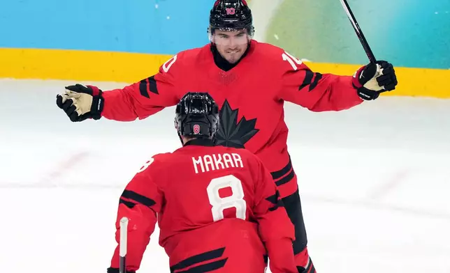Canada's Nick Suzuki (10) celebrates with Cale Makar (8) after Suzuki scored a goal against Czechia during the third period of a men's ice hockey quarterfinal game at the 2026 Winter Olympics, in Milan, Italy, Wednesday, Feb. 18, 2026. (AP Photo/Carolyn Kaster)