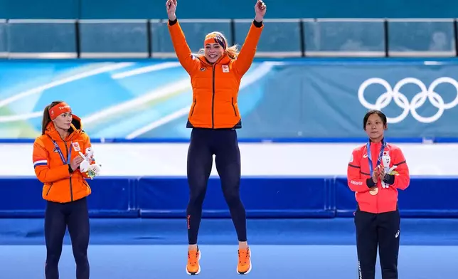 Jutta Leerdam of the Netherlands, center and gold medal, Femke Kok of the Netherlands, left and silver medal, and Japan's Miho Takagi, right and bronze medal, pose on the podium of the women's 1,000 meters speedskating race at the 2026 Winter Olympics, in Milan, Italy, Monday, Feb. 9, 2026. (AP Photo/Ben Curtis)