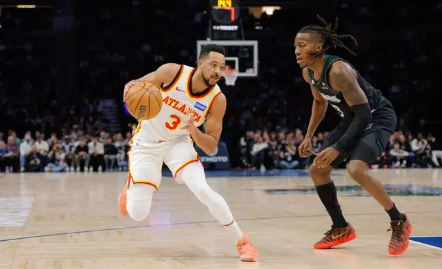 Atlanta Hawks guard CJ McCollum, left, drives while Minnesota Timberwolves guard Ayo Dosunmu, right, defends during the first half of an NBA basketball game, Monday, Feb. 9, 2026, in Minneapolis. (AP Photo/Bailey Hillesheim)
