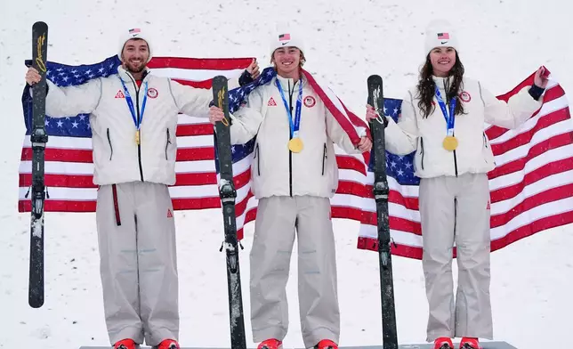 Gold medalists United States' Christopher Lillis, Connor Curran and Kaila Kuhn celebrate after the freestyle skiing mixed team aerials final at the 2026 Winter Olympics, in Livigno, Italy, Saturday, Feb. 21, 2026. (AP Photo/Gregory Bull)