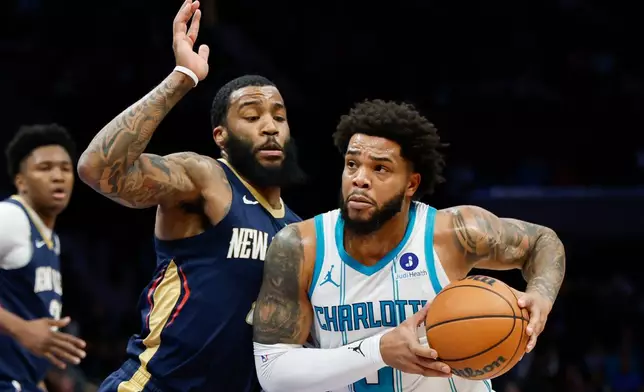 Charlotte Hornets forward Miles Bridges, right, drives to the basket against New Orleans Pelicans guard Saddiq Bey during the first half of an NBA basketball game, in Charlotte, N.C., Monday, Feb. 2, 2026. (AP Photo/Nell Redmond)