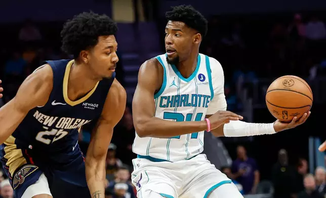 Charlotte Hornets forward Brandon Miller, right, looks to pass the ball against New Orleans Pelicans forward Trey Murphy III, left, during the first half of an NBA basketball game in Charlotte, N.C., Monday, Feb. 2, 2026. (AP Photo/Nell Redmond)