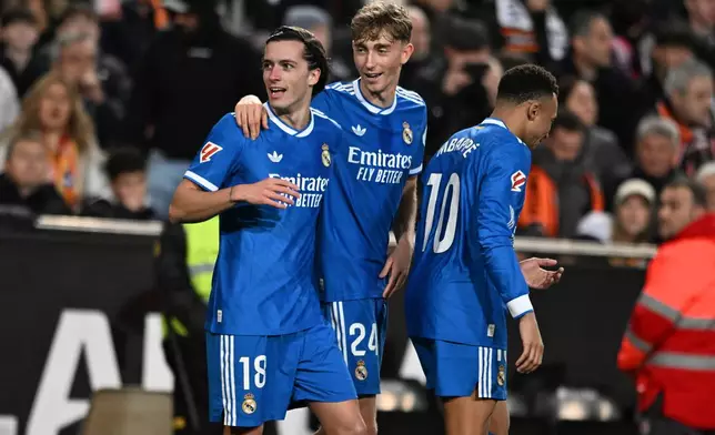 Real Madrid's Alvaro Carreras, left, celebrates with Dean Huijsen, centre and Kylian Mbappe after scoring the opening goal during the Spanish La Liga soccer match between Valencia and Real Madrid in Valencia, Spain, Sunday, Feb. 8, 2026. (AP Photo/Francisco Macia)