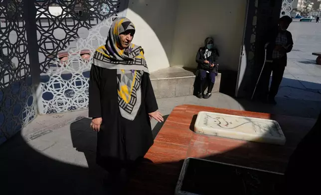 People pray at the graves of Iranian soldiers who were killed during 1980-88 Iraq-Iran war, in downtown Tehran, Iran, Tuesday, Feb. 17, 2026. (AP Photo/Vahid Salemi)