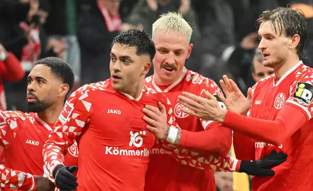 Mainz's Nadiem Amiri, center left, celebrates scoring with teammates during the Bundesliga soccer match between Mainz 05 and Hamburger SV in Mainz, Germany, Friday Feb. 20, 2026. (Torsten Silz/dpa via AP)