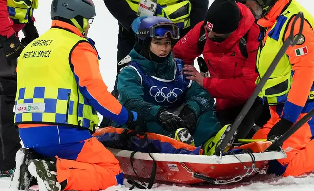 Medics tend to Switzerland's Mathilde Gremaud after she crashed during practice before the women's freestyle skiing big air finals at the 2026 Winter Olympics, in Livigno, Italy, Monday, Feb. 16, 2026. (AP Photo/Gregory Bull)